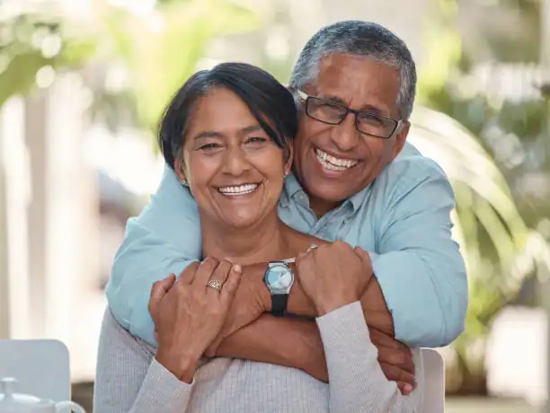Older couple enjoying joyful moment together in a park setting.